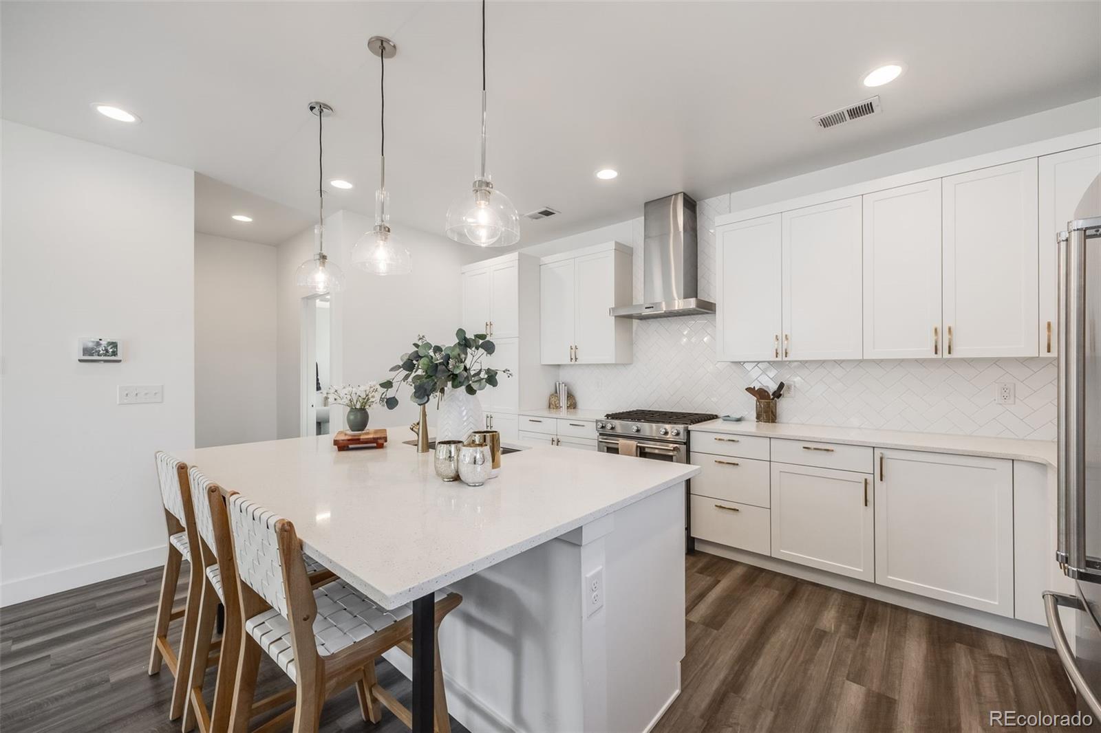 3011 West 53rd Avenue Denver, CO 80221 - Photo 14 of 44 a kitchen with a dining table chairs sink and cabinets