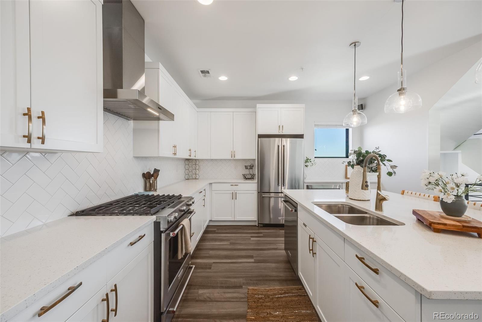 3011 West 53rd Avenue Denver, CO 80221 - Photo 16 of 44 a kitchen with stainless steel appliances granite countertop a sink a stove and a refrigerator