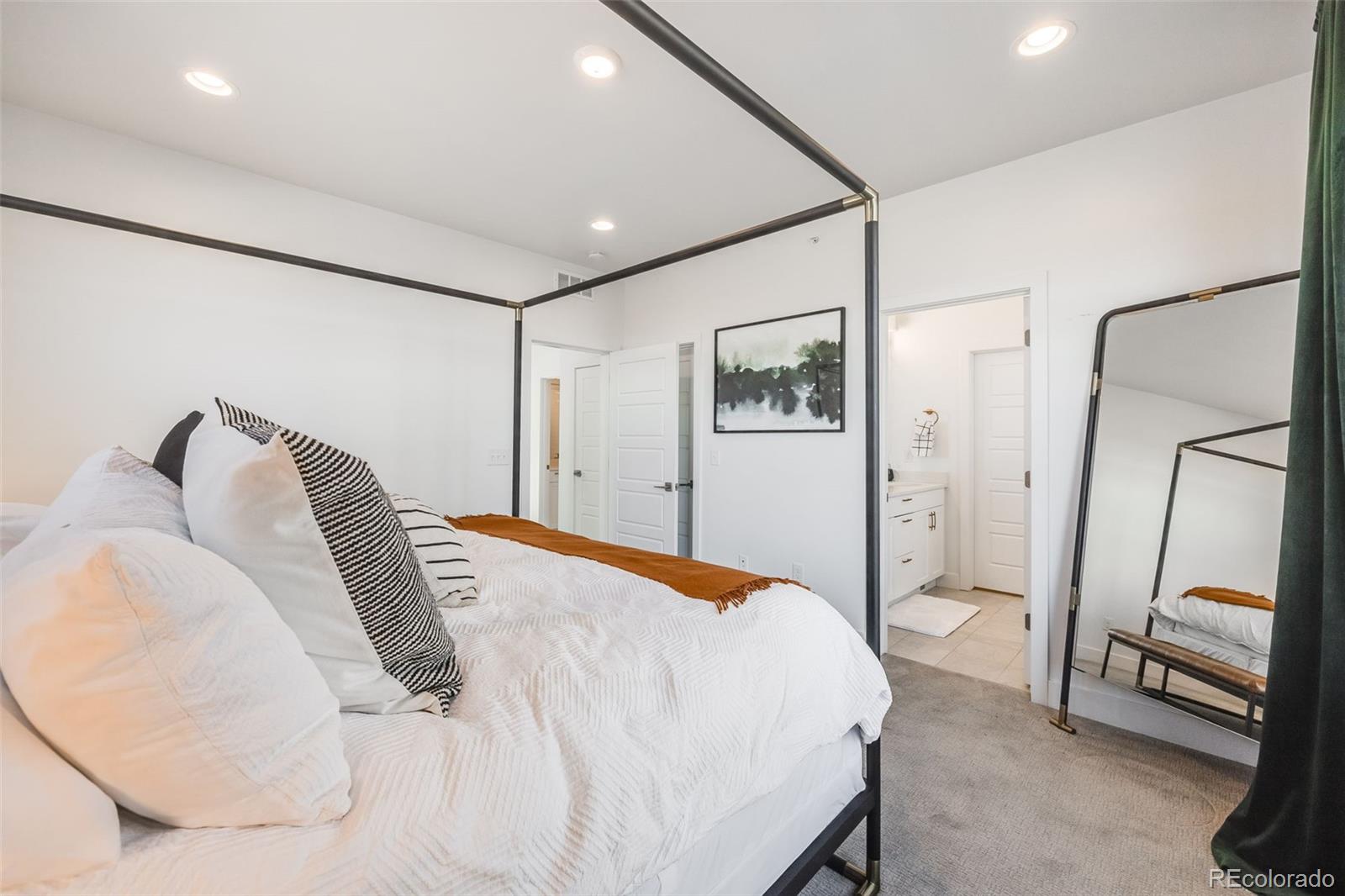 3011 West 53rd Avenue Denver, CO 80221 - Photo 30 of 44 a bedroom with a bed and a mirror