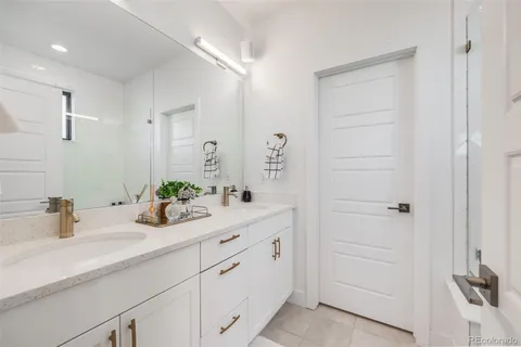 a en suite bathroom with a granite countertop sink mirror and shower