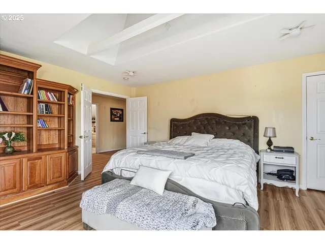 a bedroom with a large bed a chandelier and a book shelf