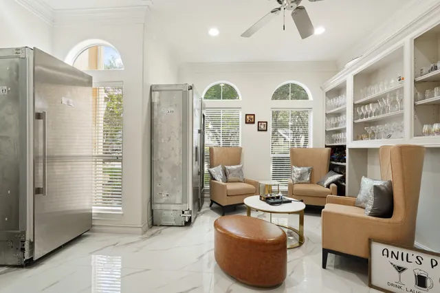 a living room with furniture a large window and chandelier