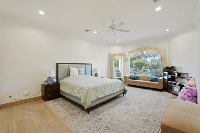 a spacious bedroom with a bed and wooden floor