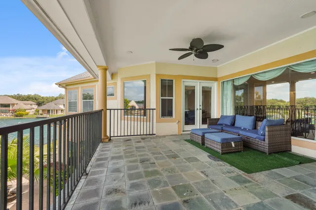 a view of a patio with couches potted plants and wooden roof