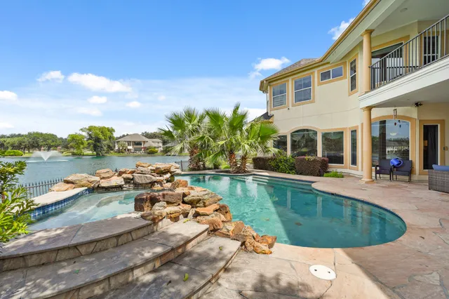 a view of a house with pool and sitting area