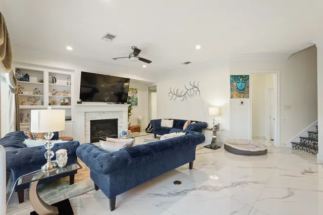 a living room with furniture a flat screen tv and a fireplace