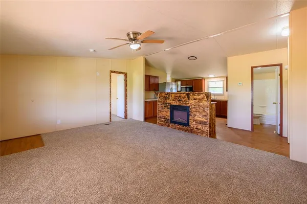 a view of an empty room with a chandelier fan