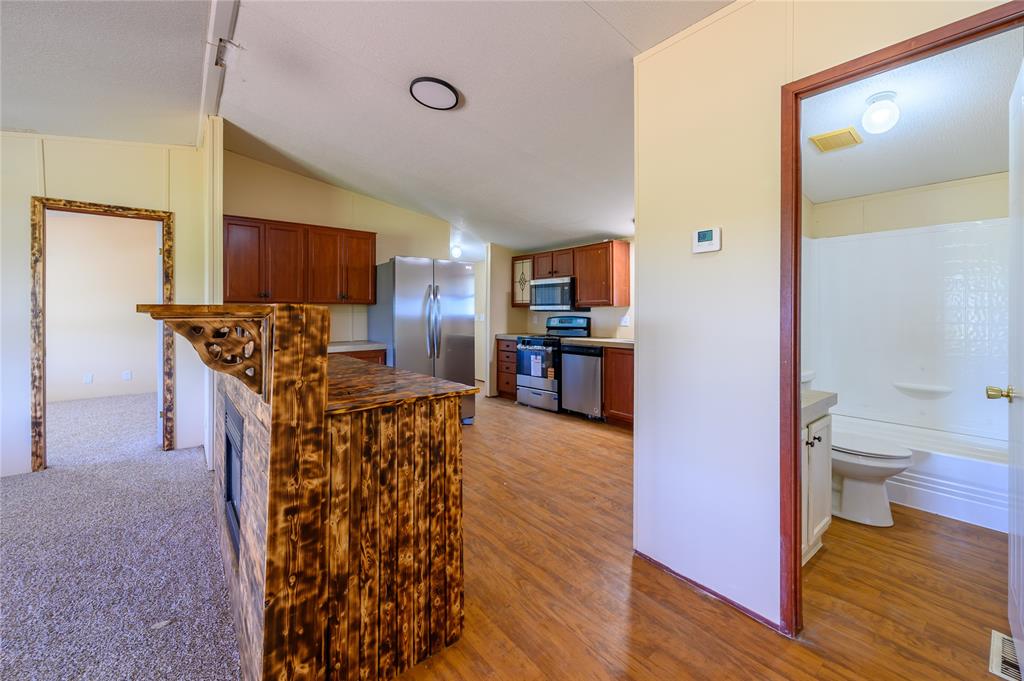 383 Soaring Eagle Trail Wichita Falls, TX 76310 - Photo 12 of 36 Kitchen featuring wood finish cabinetry, stainless steel appliances, and vaulted ceiling