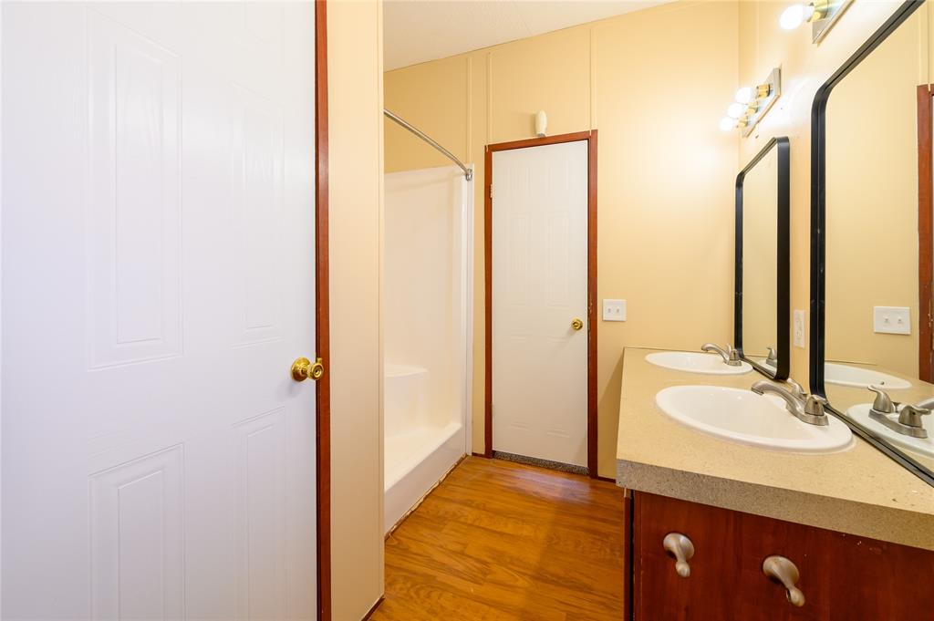 383 Soaring Eagle Trail Wichita Falls, TX 76310 - Photo 17 of 36 Bathroom featuring double vanity, a walk in shower, and light wood-style flooring