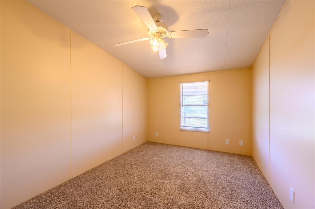 383 Soaring Eagle Trail Wichita Falls, TX 76310 - Photo 21 of 36 Spare room with carpet floors, ceiling fan, and a decorative wall