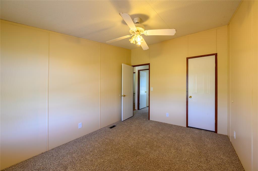 383 Soaring Eagle Trail Wichita Falls, TX 76310 - Photo 22 of 36 Unfurnished bedroom with carpet floors, ceiling fan, and a decorative wall