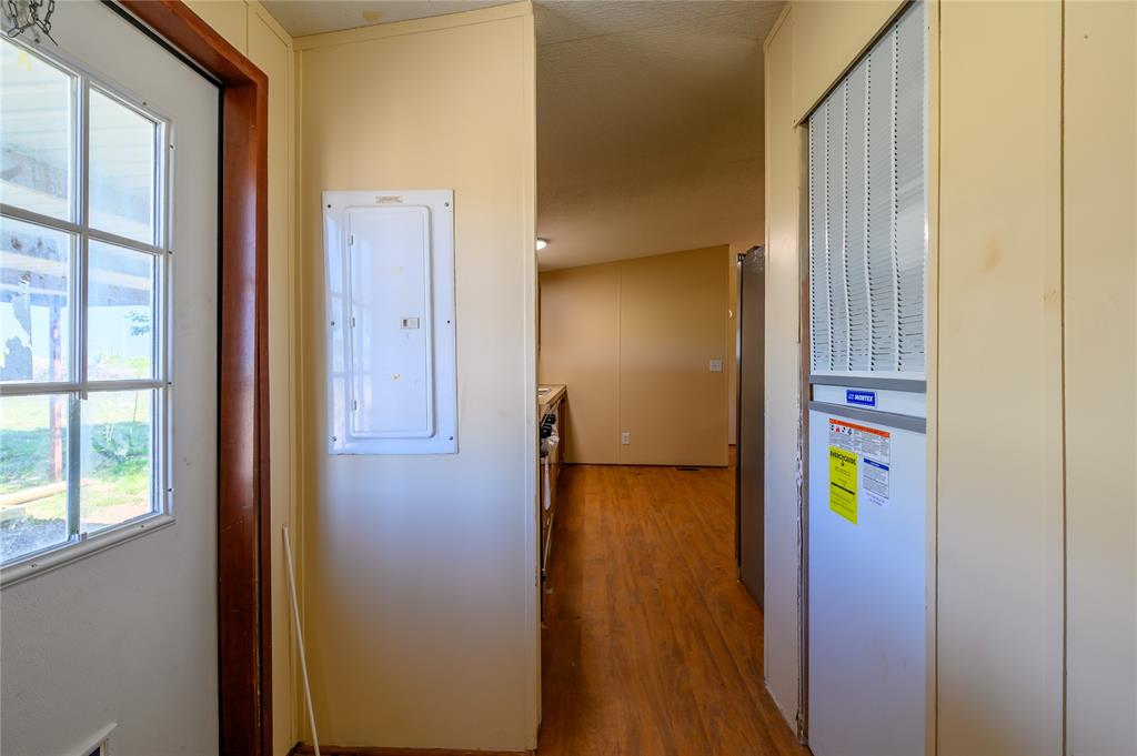 383 Soaring Eagle Trail Wichita Falls, TX 76310 - Photo 24 of 36 Corridor with electric panel, a heating unit, and light wood finished floors