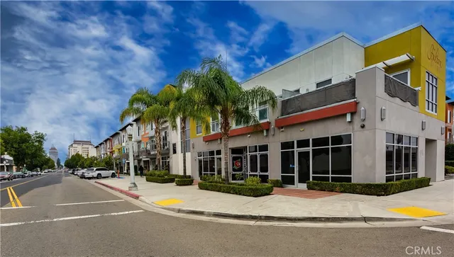 a view of a white building with palm tree in front of it