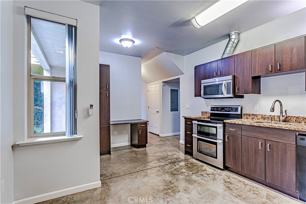 1759 Fulton Street Fresno, CA 93721 - Photo 15 of 24 a kitchen with stainless steel appliances granite countertop a stove top oven a sink dishwasher a dining table and chairs with wooden floor