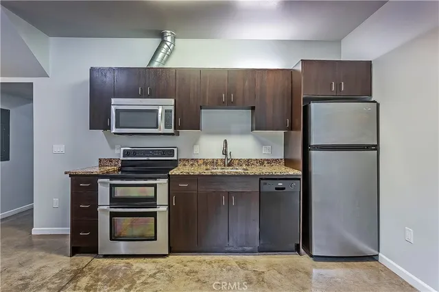 a kitchen with stainless steel appliances granite countertop a refrigerator stove and sink