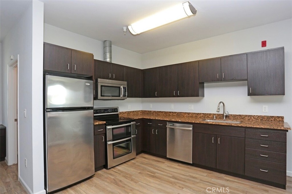 1759 Fulton Street Fresno, CA 93721 - Photo 21 of 24 a kitchen with kitchen island granite countertop stainless steel appliances and wooden cabinets