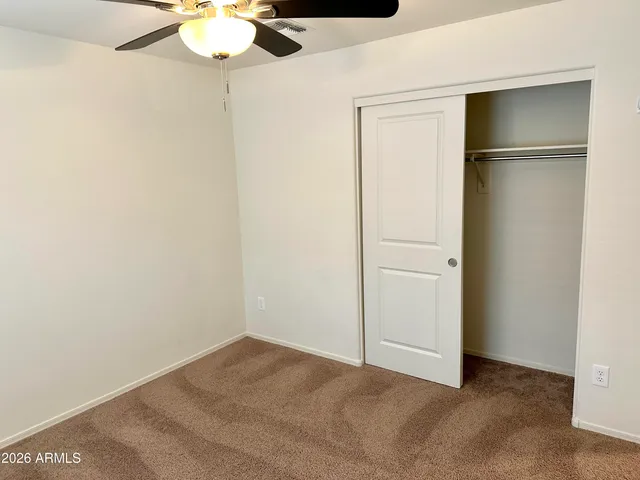 an empty room with a window and a fan