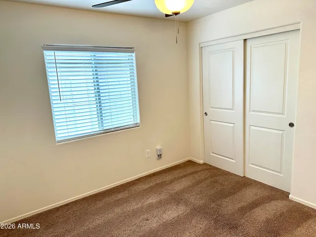 a view of an empty room with window and cabinet