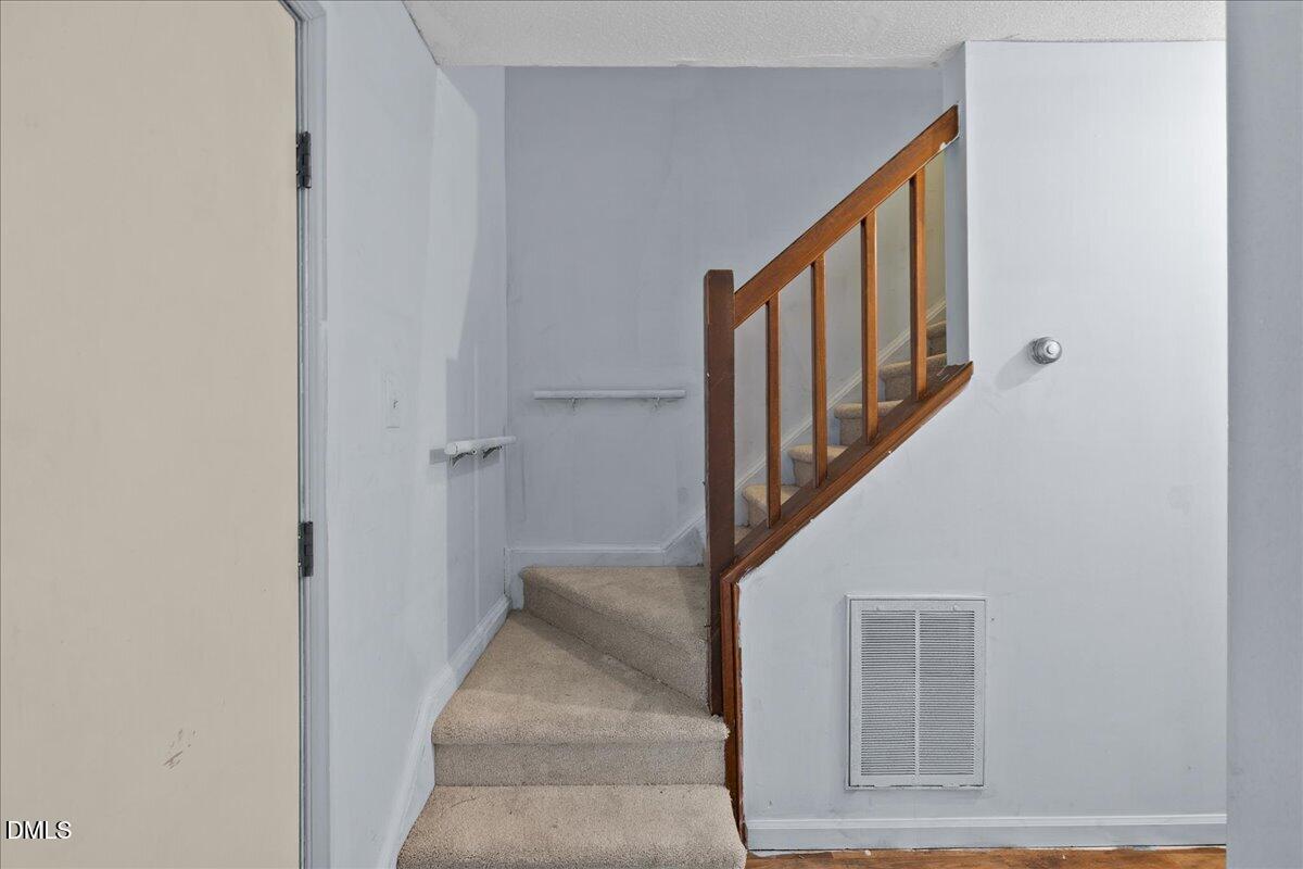 4409 Lake Ridge Drive Raleigh, NC 27604 - Photo 18 of 31 a view of staircase with lots of frames on wall and a window