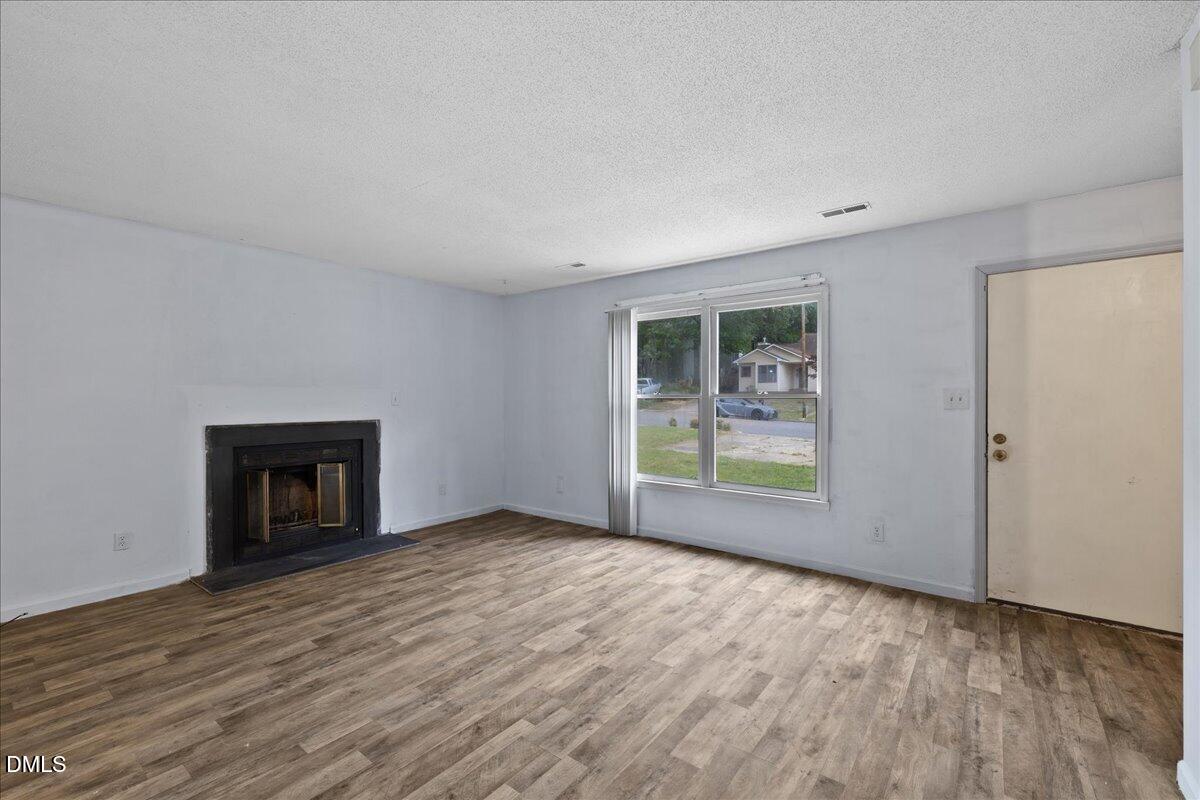 4409 Lake Ridge Drive Raleigh, NC 27604 - Photo 7 of 31 an empty room with windows and fireplace