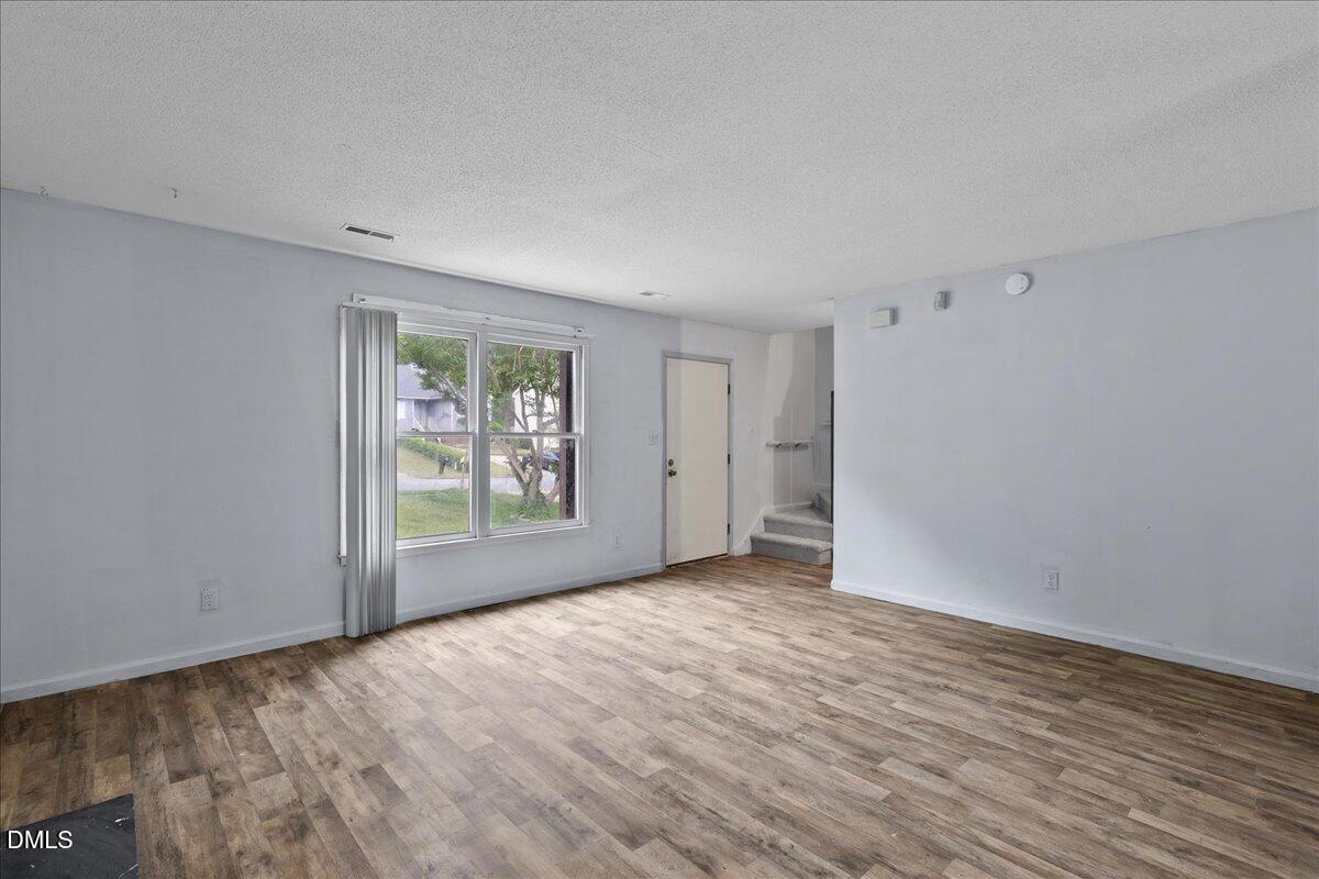 4409 Lake Ridge Drive Raleigh, NC 27604 - Photo 8 of 31 a view of an empty room with wooden floor and a window