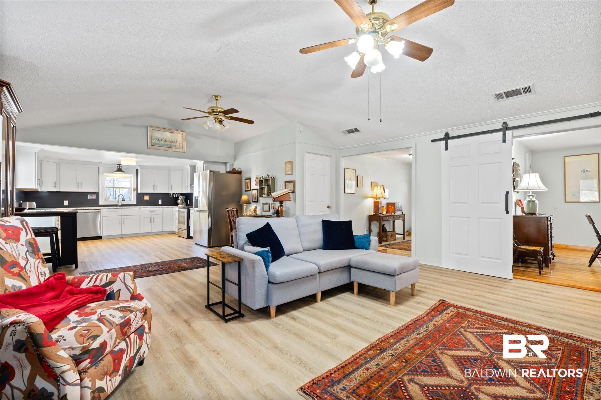14280 Cat Deakle Road Grand Bay, AL 36541 - Photo 5 of 51 Living room featuring lofted ceiling, a barn door, light wood-type flooring, and visible vents