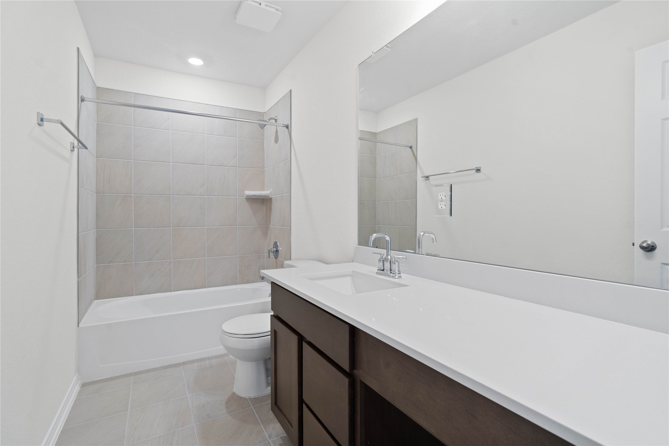 6403 Canby Court Rosharon, TX 77583 - Photo 16 of 23 The secondary bathroom offers tile flooring, a bath/shower combination with a stylish tile surround, rich stained wood cabinetry, elegant light countertops, a mirror, and sleek fixtures with modern finishes.