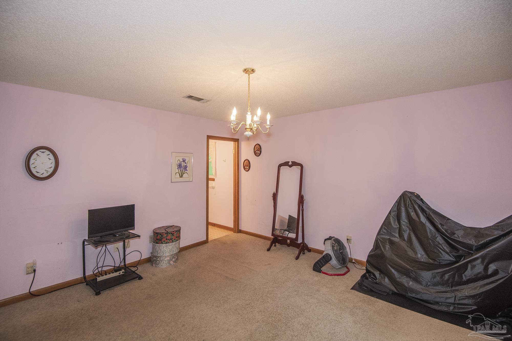 1210 Goldenrod Road Cantonment, FL 32533 - Photo 24 of 50 a room with gym equipment and a flat screen tv