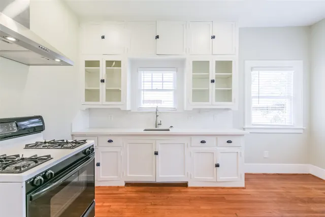 a kitchen with granite countertop a sink a stove and cabinets