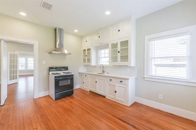 a kitchen with stainless steel appliances granite countertop a stove and a wooden floors