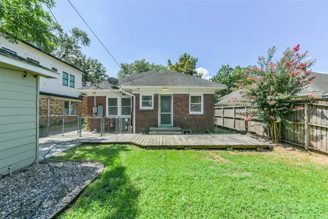 a front view of a house with a yard and potted plants