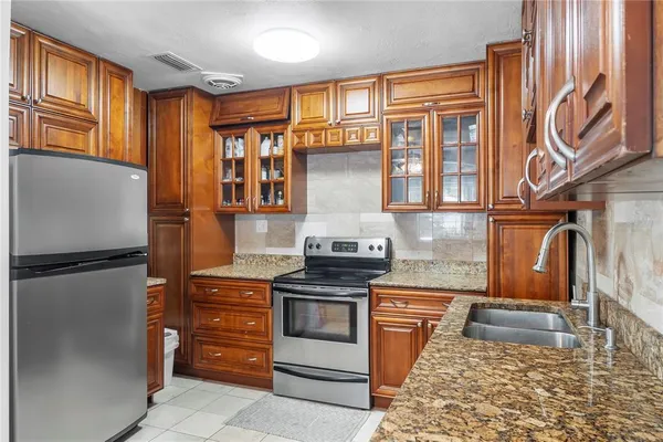 a kitchen with stainless steel appliances granite countertop a refrigerator stove and sink
