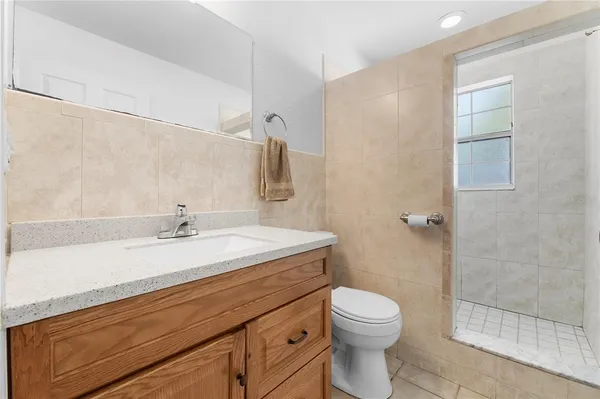 a bathroom with a granite countertop toilet a sink and a mirror