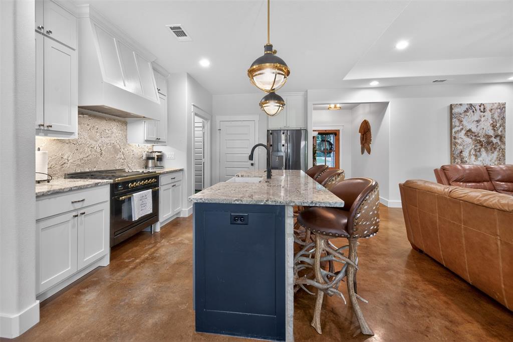 6371 Mill Run Road Athens, TX 75751 - Photo 7 of 40 The kitchen features white cabinetry, a dark blue island with a light-colored countertop, and a ILVE high end range
