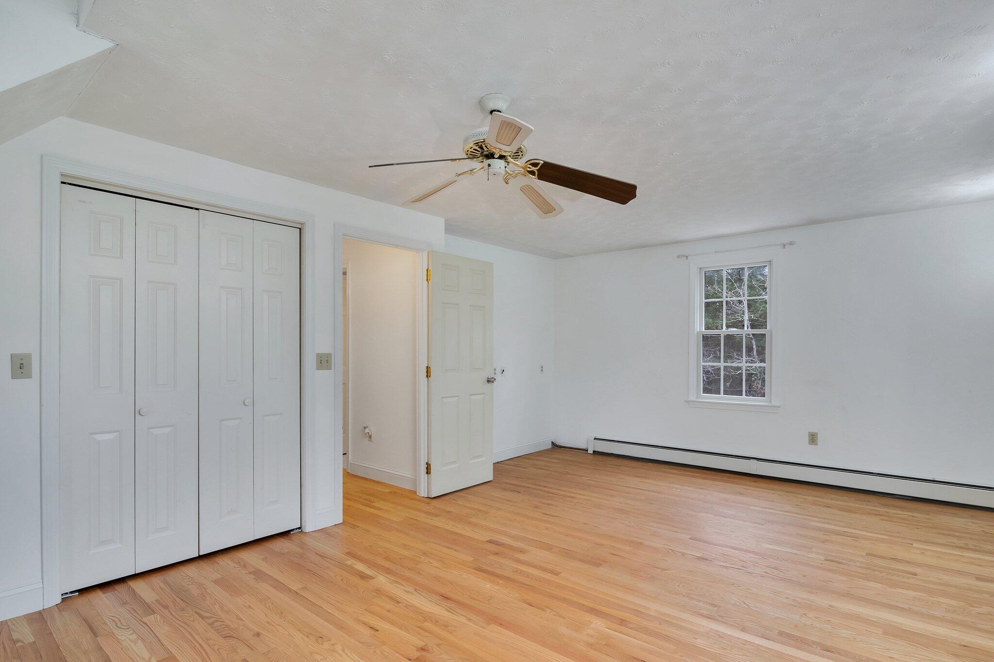 2 Windsor Way Mashpee, MA 02649 - Photo 32 of 53 a view of an empty room with wooden floor and a ceiling fan