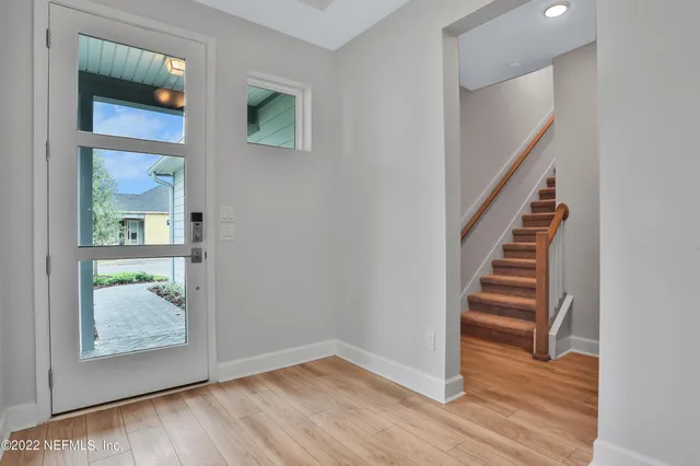 a view of entryway and hall with wooden floor