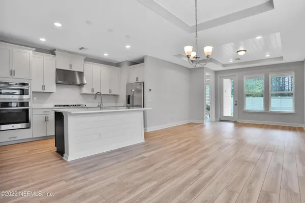 a kitchen with stainless steel appliances granite countertop a wooden floors and white cabinets