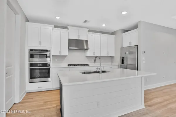 a kitchen with stainless steel appliances a stove a sink and a refrigerator
