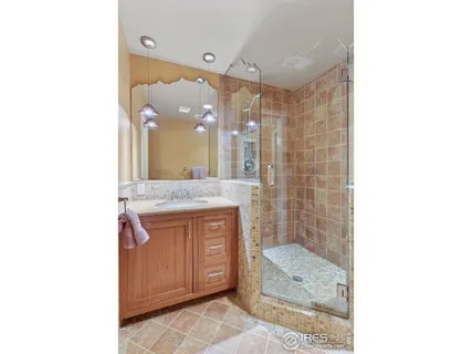 a bathroom with a granite countertop sink a mirror and a shower