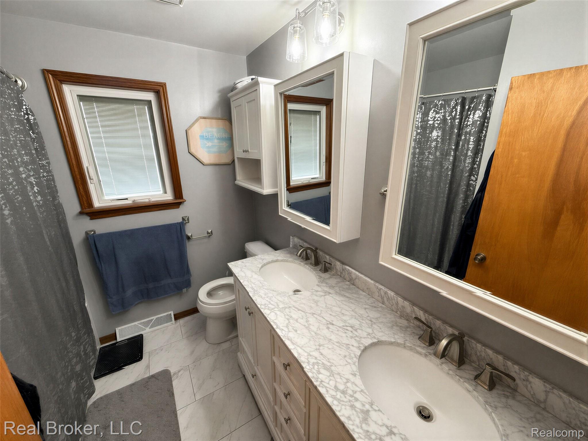 3412 South Reese Road Frankenmuth, MI 48734 - Photo 10 of 17 Bathroom featuring double vanity, a shower with curtain, and light marble finish flooring
