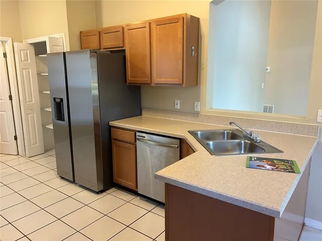 a kitchen with stainless steel appliances a refrigerator sink and microwave
