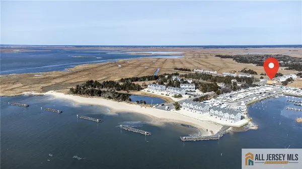 an aerial view of ocean and residential houses with outdoor space
