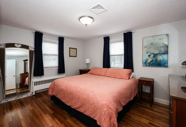a bed sitting in a spacious bedroom next to a window