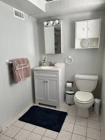 a bathroom with a toilet a sink and mirror