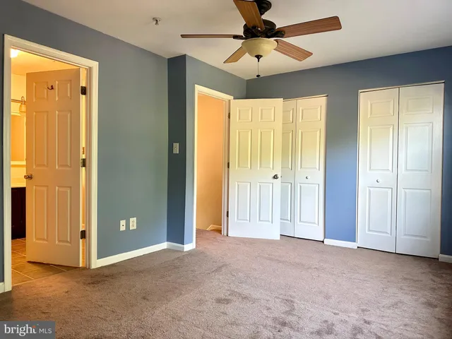 a view of empty room with chandelier fan