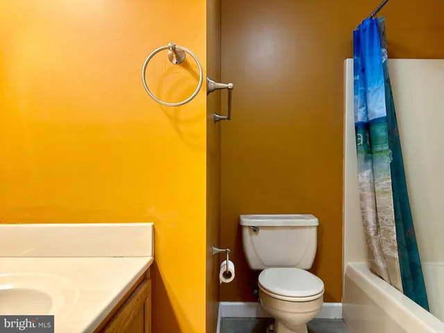 a white toilet sitting next to a bathroom sink and a mirror