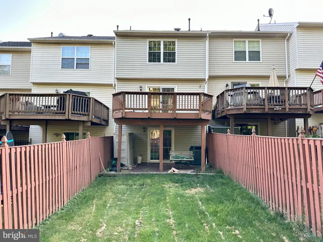 a view of a house with wooden deck and furniture