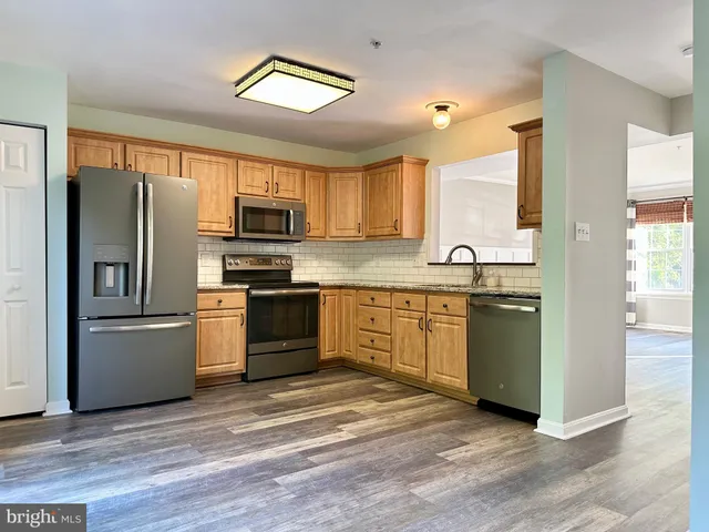 a kitchen with granite countertop a refrigerator stove and sink
