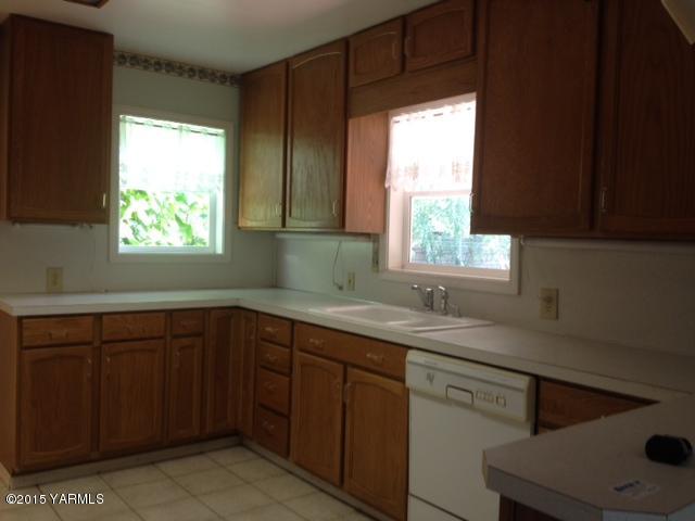 2490 Ashue Road Wapato, WA 98951 - Photo 7 of 11 a kitchen with a sink window and cabinets