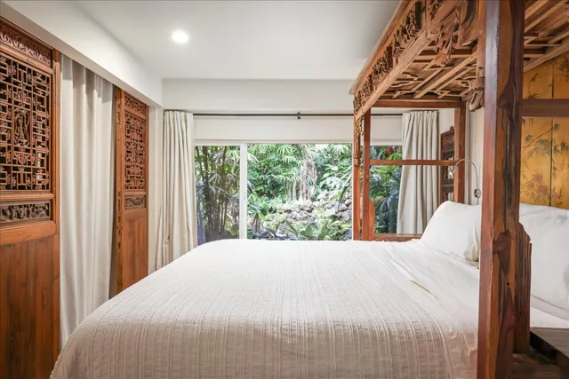 a large bedroom with a bed and a large window